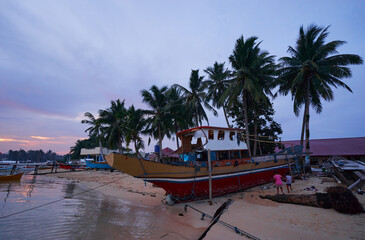 Beautiful tropical landscape with traditional wooden fishing boats on the sea shore.