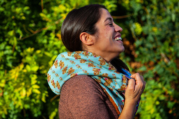 woman laughing and smiling over green leaves background. 