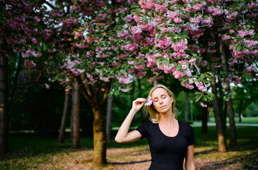 Blonde young woman at blossom garden.