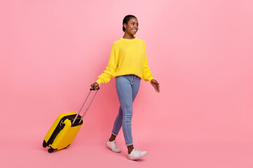 Full length profile photo of pretty cheerful girl look empty space walk isolated on pink color background