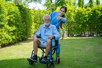 Fototapeta premium Nurses help and encourage for senior man on wheelchair in their home,Therapy physical rehab exercises.