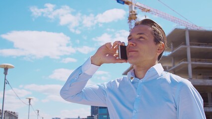 Business person standing in front of construction site. Office building and crane background. Development, real estate and investment.