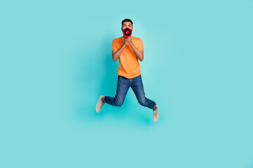 Fototapeta na wymiar Full body photo of overjoyed person jumping hands hold loudspeaker say isolated on turquoise color background