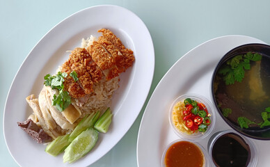 Boiled Chicken Rice Mixed with Fried Chicken Served with broth and dipping sauce, top view. The most popular street food in Thailand is called Khao Mun Gai.