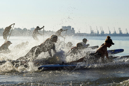 People starts on SUP from the shore. River beach start on rowing competitions on SUP (stand up paddle boarding)