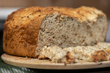Appetizing homemade bread with a golden crust lies on a wooden board