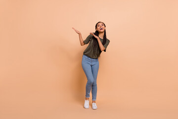 Full size portrait of overjoyed satisfied girl enjoy free time dancing clubbing isolated on beige color background