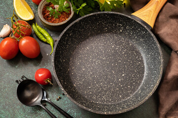 Food cooking background with Frying pan. Empty skillet, vegetables, spices and herbs on dark table background.