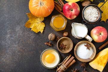 Autumn baking food background with pumpkins, apples, honey, nuts and seasonal spices on a stone table. Pumpkin or apple pie for Thanksgiving and autumn holidays. View from above. Copy space.