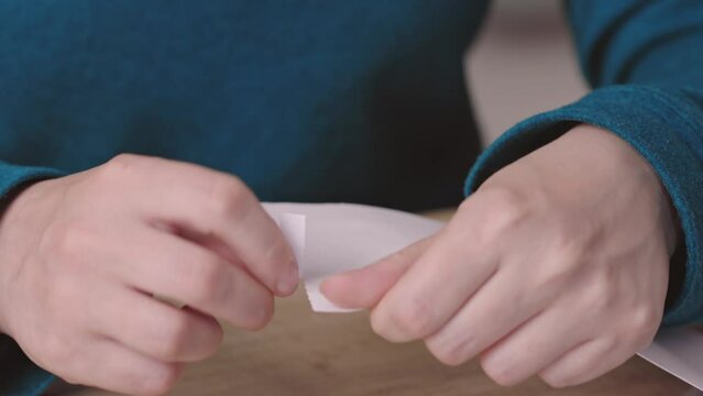 close-up female hands pull out paper envelope utility bill paper letter bank documents. caucasian woman hands opening paper letter post invoice tax forms. tear paper envelope concept