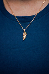 Fototapeta na wymiar Gold necklace on blue background jewelry fashion 