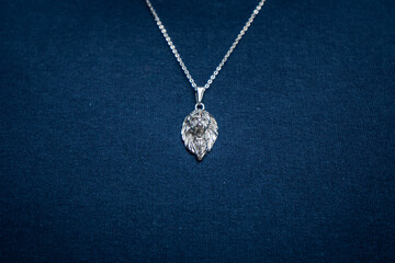 Fototapeta na wymiar Silver necklace on blue background jewelry fashion 