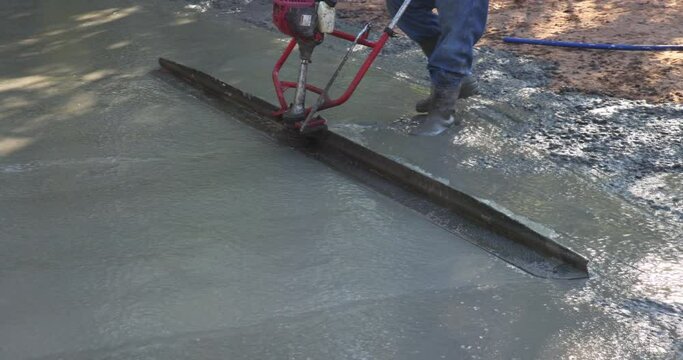 An alignment machine is used to align new fundation compacted layer of fresh concrete on new driveways constructed.