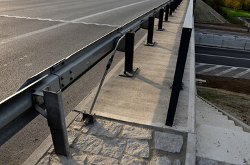 connection of metal and concrete highway barriers with screws. reinforcement with metal struts and...