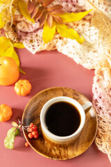 Autumnal breakfast. Composition fall leaves, hot cup of coffee and warm scarf. Cozy autumn season concept. Copy space.
