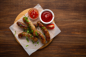 Top view of lamb beef grilled sausages smoked food and dips on wood