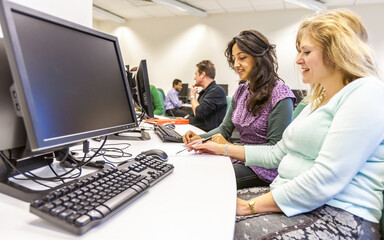 Adult Education: Working Together. Mature students at work in their college computer suite. From a...