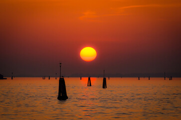 Il sole scende sul mare sulla laguna di Venezia in un bel tramonto arancione
