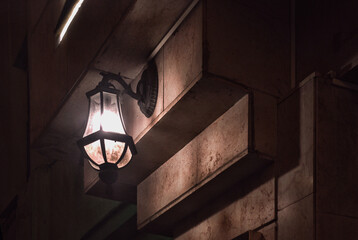 Light fixture hanging on the facade of a building at night