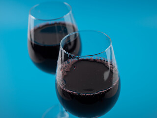 A glass of wine on a blue background.