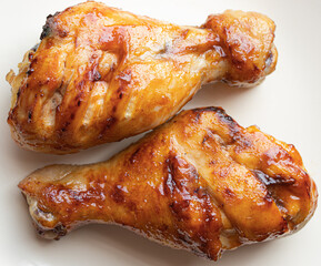 Two seasoned baked chicken drumsticks
