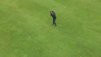 OVERHEAD AERIAL Drone shot of Caucasian male playing golf, striking a ball during the course. Super slow motion shot