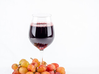 A glass of wine and grapes on a white background.