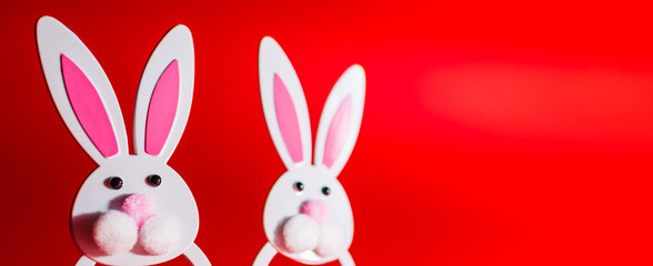 Banner,advertisement image.Two Toy Rabbit Bunny symbol of new year 2023 on red background.Christmas or New Year concept.Copy space.