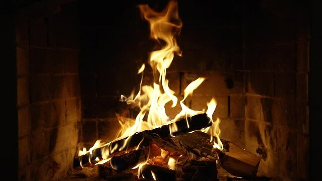 Fireplace Burning Wood Logs, Cozy Warm Home Christmas Time Burning Fire In The Fireplace. Slow Motion. A Looping Clip of a Hearth with Medium Size Flames. UHD TV screen saver. Video for meditation