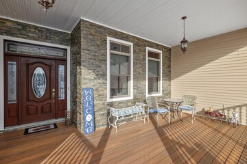 Wooden deck with a brown entry door and other outdoor furniture pieces