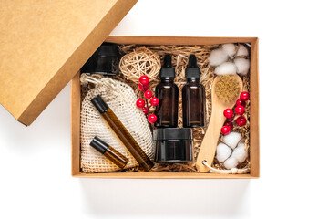 Set for care box Eco-friendly cosmetics Oil and cream bottles, brush for washing, cotton pads on green background Gift for girlfriend, mother to celebrate Christmas concept Top view Flat lay