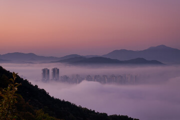 Scenic view of the city under the fog during sunrise