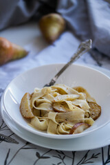 Homemade Italian pasta with pear in a white plate