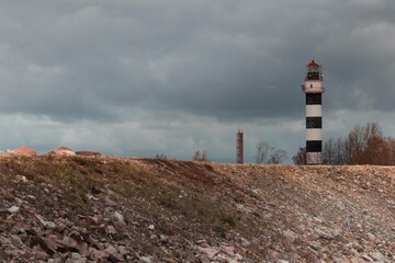 lighthouse on the coast,sea ​​lighthouse behind a rocky embankment, sea landscape