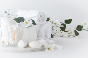 Fototapeta na wymiar An arrangement of white cleansing items against a white background.