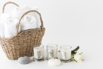 A basket of towels with candles in front and copy space to the right. 