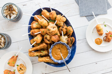 A platter of deep fried appetizers with hot mustard sauce, ready for sharing.