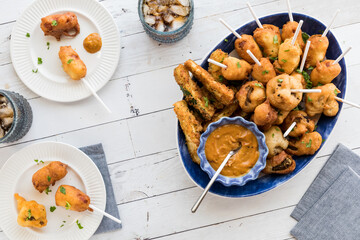A platter of deep fried appetizers served with hot mustard for dipping.