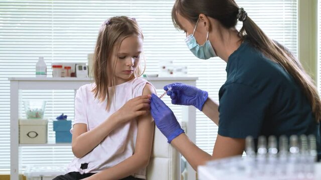 Female nurse doctor vaccinating child. Concept of vaccination program, children's vaccination, prevention of infectious diseases, anti-coronavirus vaccination