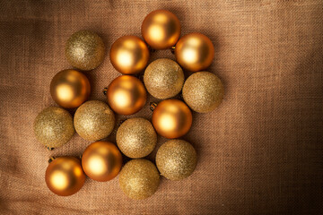 golden christmas balls with different textures and glitters on sackcloth