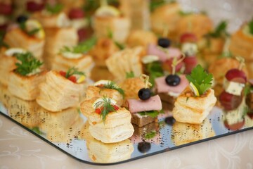Assorted canapes and various delicacies on the festive table. Snacks for guests at the event.