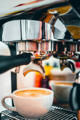 Coffee extraction from the coffee machine with a portafilter pouring coffee into a cup,Espresso...