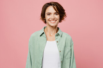 Young happy smiling cheerful fun cool woman 20s she wear mint shirt white t-shirt look camera with toothy grin isolated on plain pastel light pink background studio portrait. People lifestyle concept.