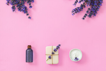 Lavender's spa products with dried lavender flowers on pink background.