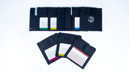 obsolete computer floppy disks with a flash drive on a white background,