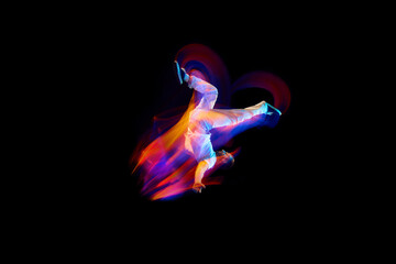 Dance in motion. Studio shot of flying, jumping dancer or gymnast performing tricks in the air over...