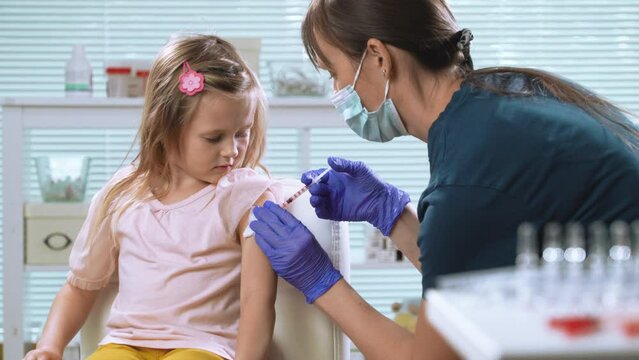 Female nurse doctor vaccinating child. Concept of vaccination program, children's vaccination, prevention of infectious diseases, anti-coronavirus vaccination