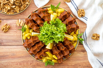 Cig kofte or raw meatballs on wood background. Traditional Turkish cuisine delicacies. Top view