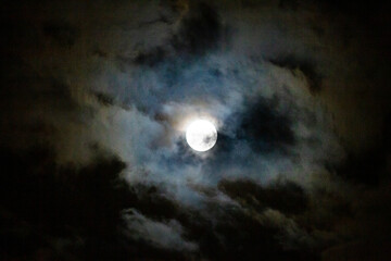Full Moon in the night sky with clouds, once in a blue moon