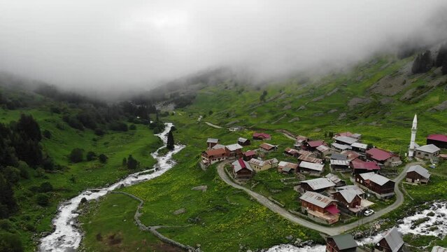 Rize aerial view with foggy weather. Drone video over houses with a red roof, a mountain river flows nearby in Elevit, Turkey